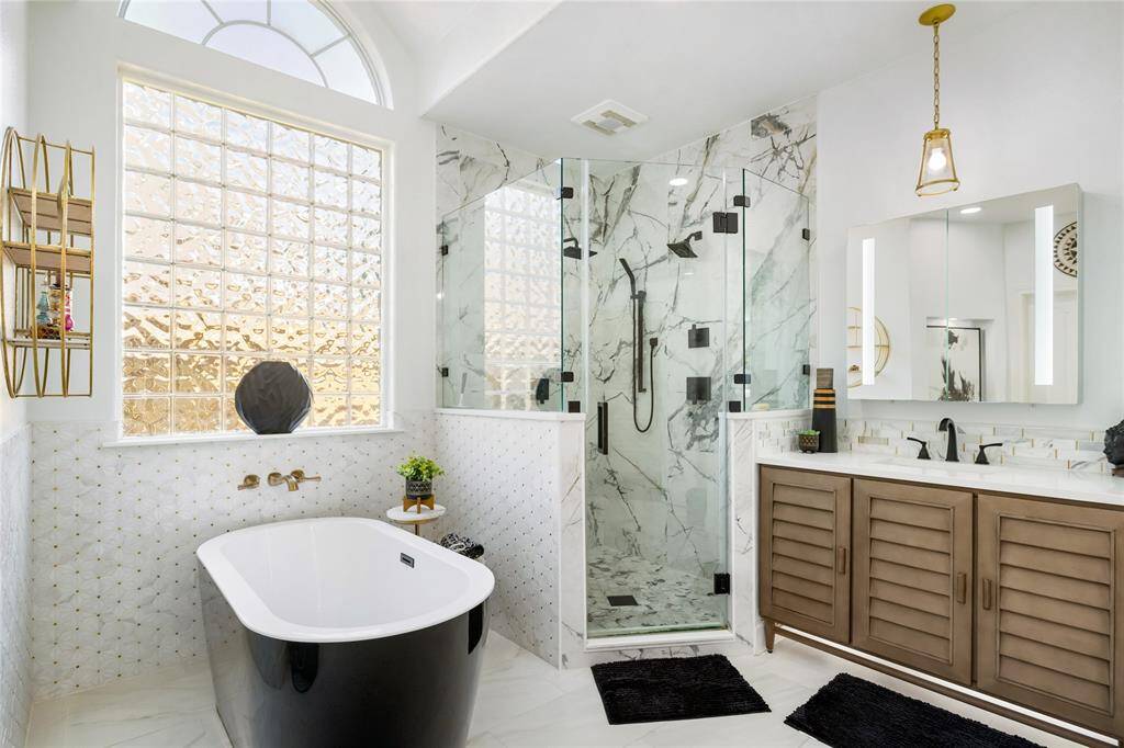 Where indulgence meets design. The heart of this spa-inspired retreat is a striking black freestanding tub, perfectly positioned beneath a sunlit window. Adjacent, the fully redesigned Hollywood shower (2023) stuns with floor-to-ceiling marble tile and seamless glass enclosure—offering both beauty and function. Every element is thoughtfully curated to create a space that feels like a luxury escape, right at home.