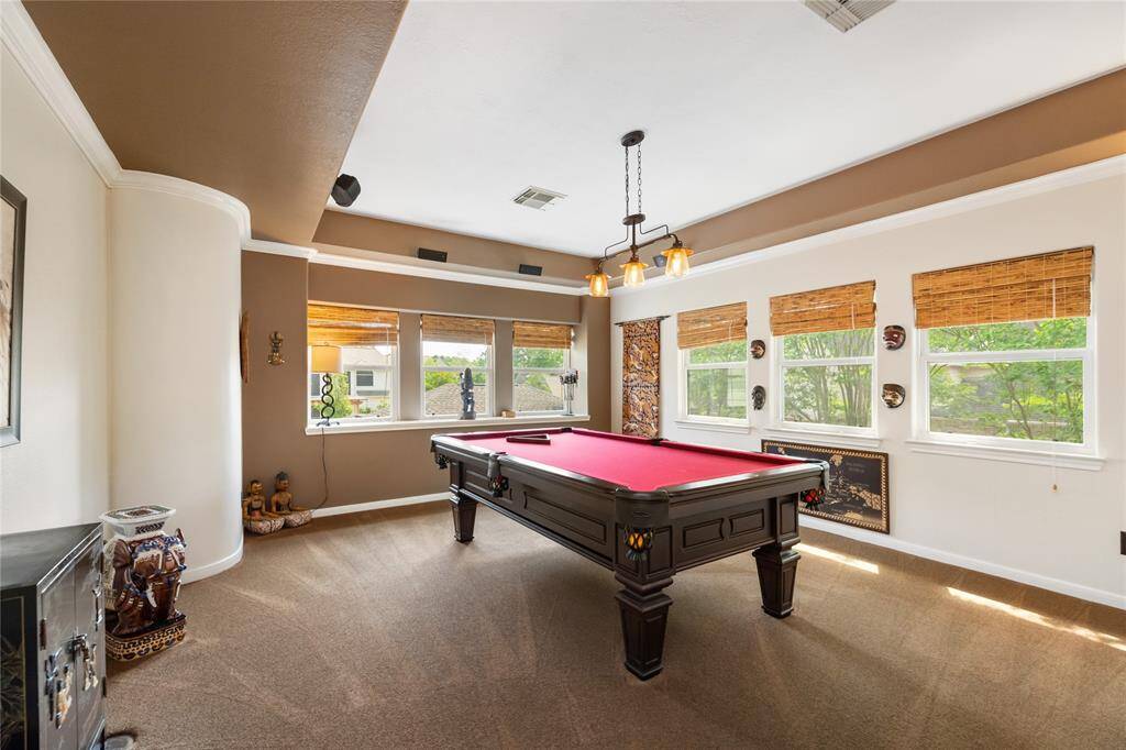 This bright game room invites endless possibilities, from lively game nights to quiet relaxation. Large windows fill the room with natural light, enhancing its welcoming atmosphere and making it an ideal spot for both entertainment and leisure.