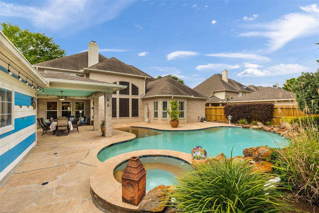Mature trees, manicured shrubs, and the home's light brick façade with large windows complete this serene setting.
