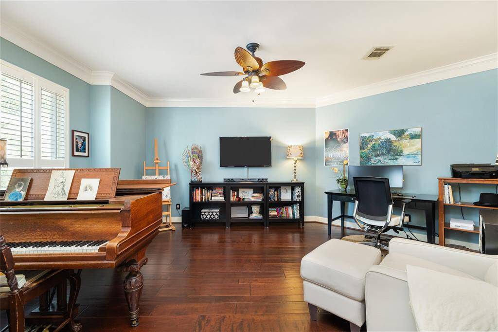 Designed for inspiration and comfort. This versatile space offers a peaceful setting for work, creativity, or quiet reflection. Soft blue walls, rich hardwood floors, and built-in shelving create a refined yet welcoming atmosphere. Whether you’re composing at a piano or focused at your desk, this room offers a balance of style, comfort, and functionality.