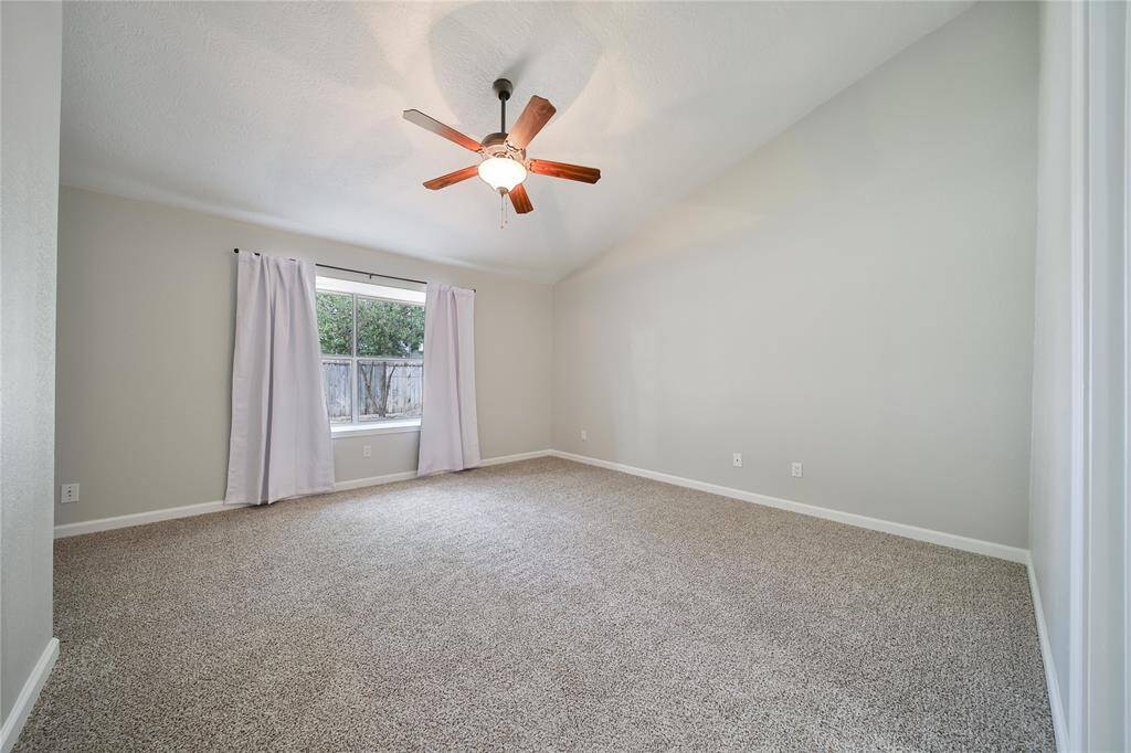 Large primary with window and backyard view.
