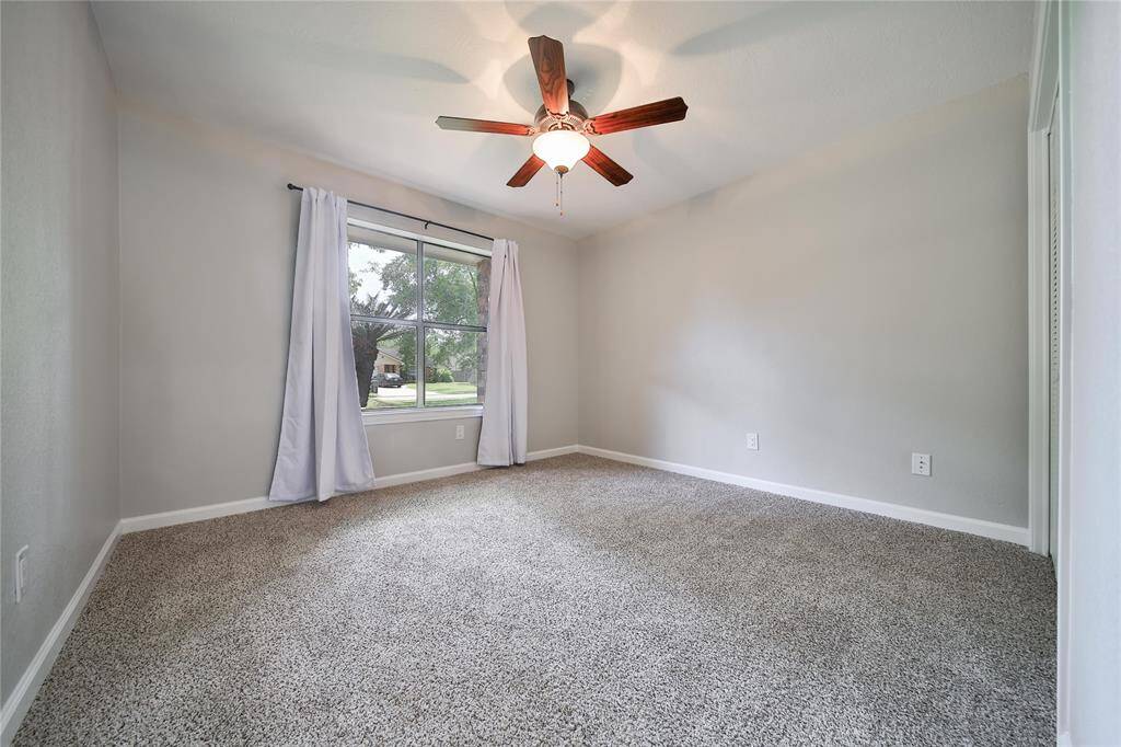 Secondary bedroom facing front yard, new ceiling fan, closet doors and carpet