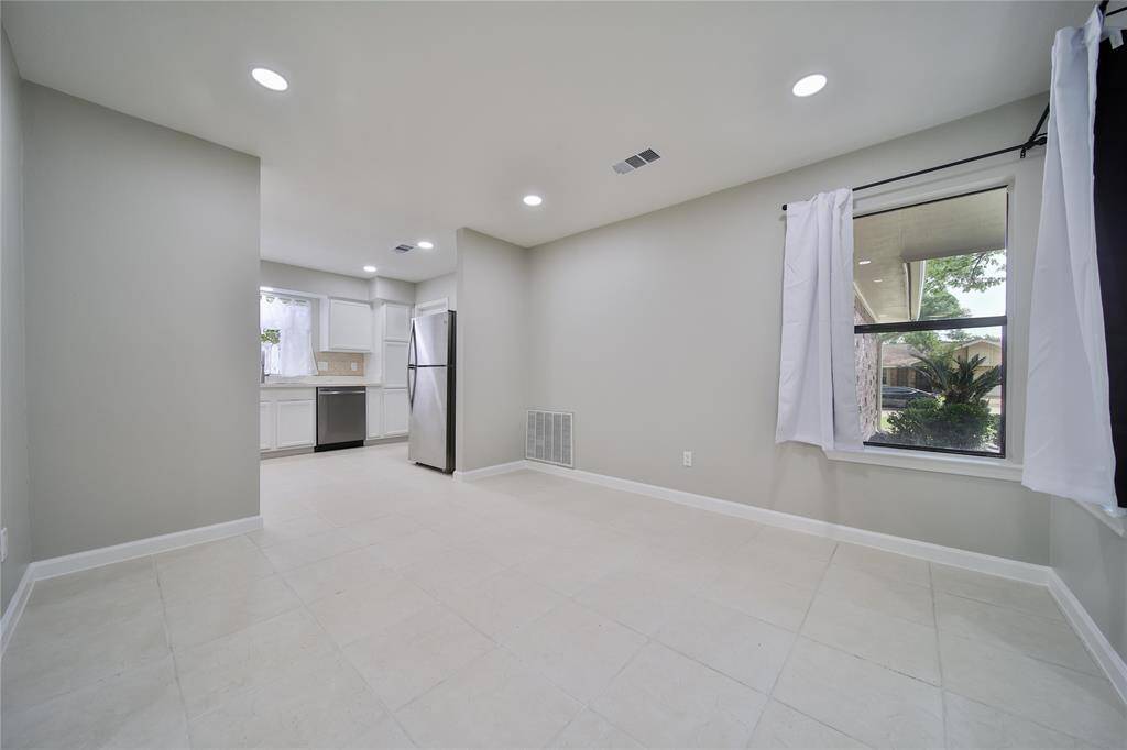 Kitchen and dining room combo is flooded with natural light with two windows.