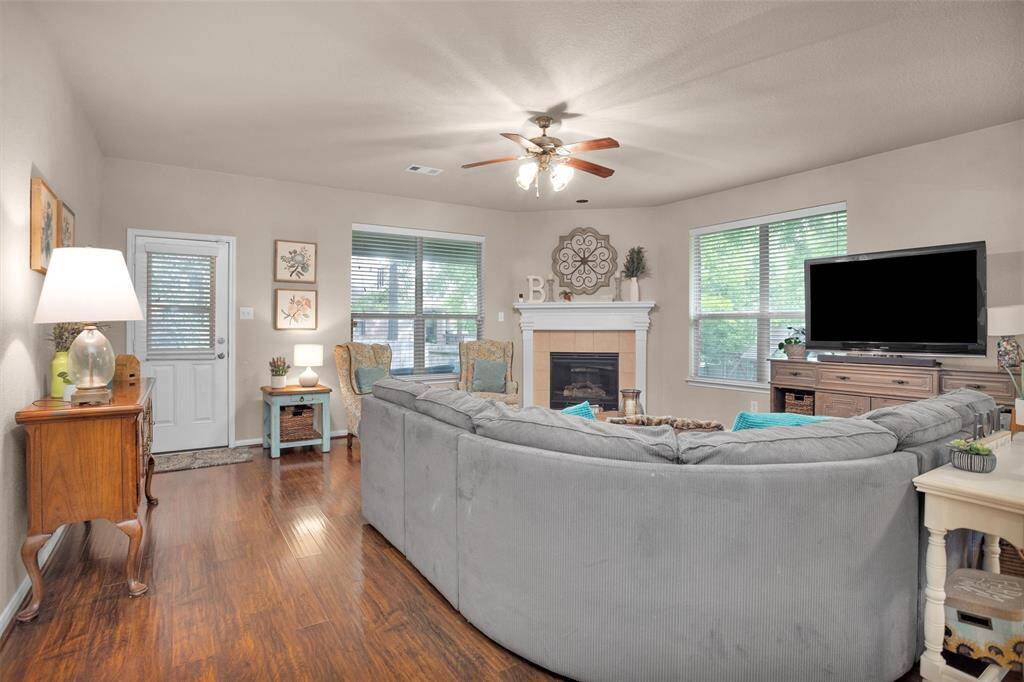 Inviting family room featuring a cozy fireplace, abundant natural light, and elegant hardwood floors—ideal for relaxation and entertaining.