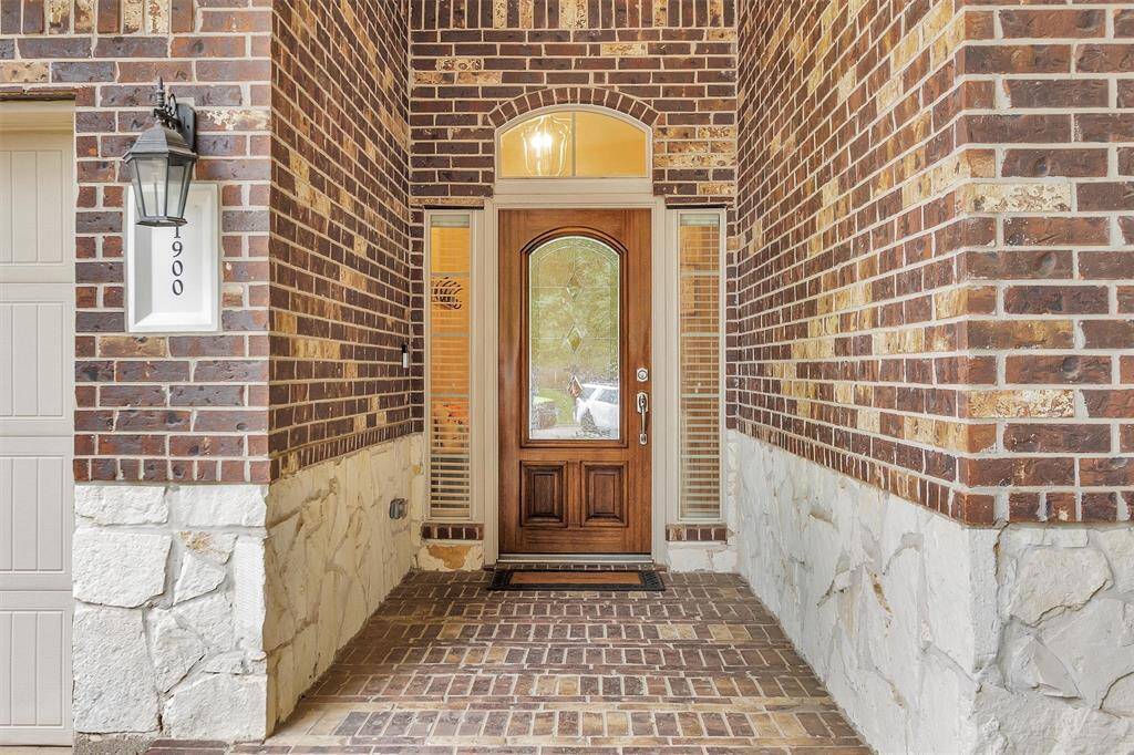 Inviting front porch with elegant brickwork and a charming wooden door.