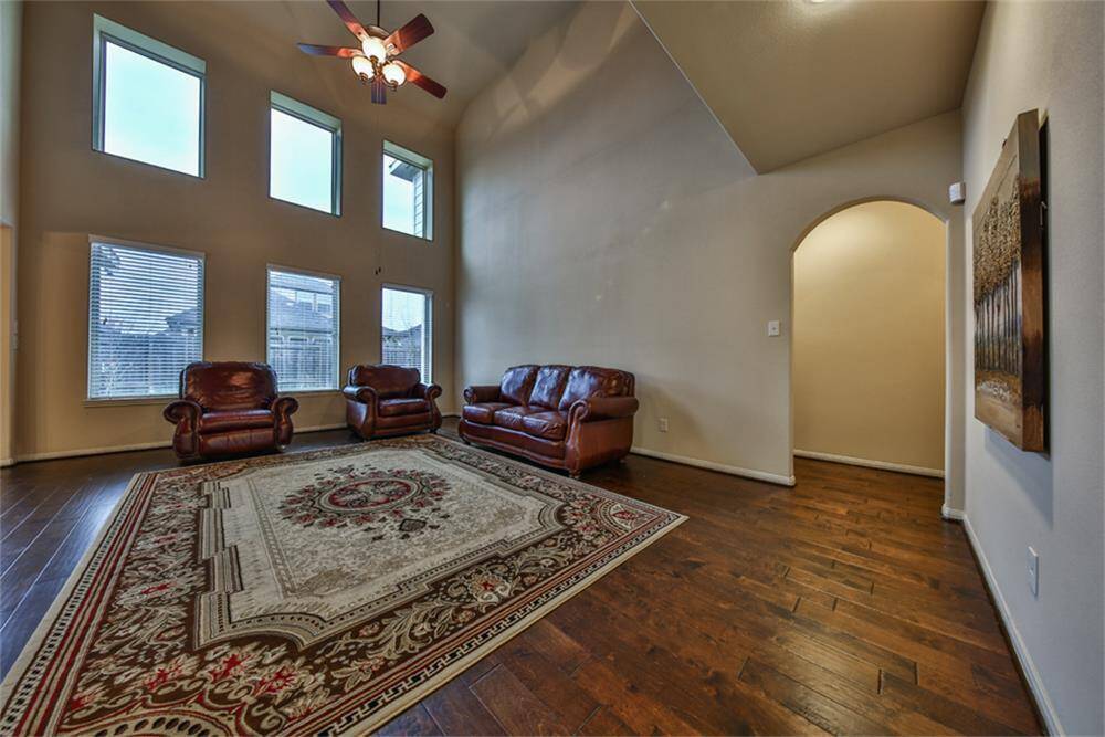 Follow the upgraded wood floors through a graceful arched doorway to the luxurious primary suite—peacefully tucked away for ultimate privacy and comfort.