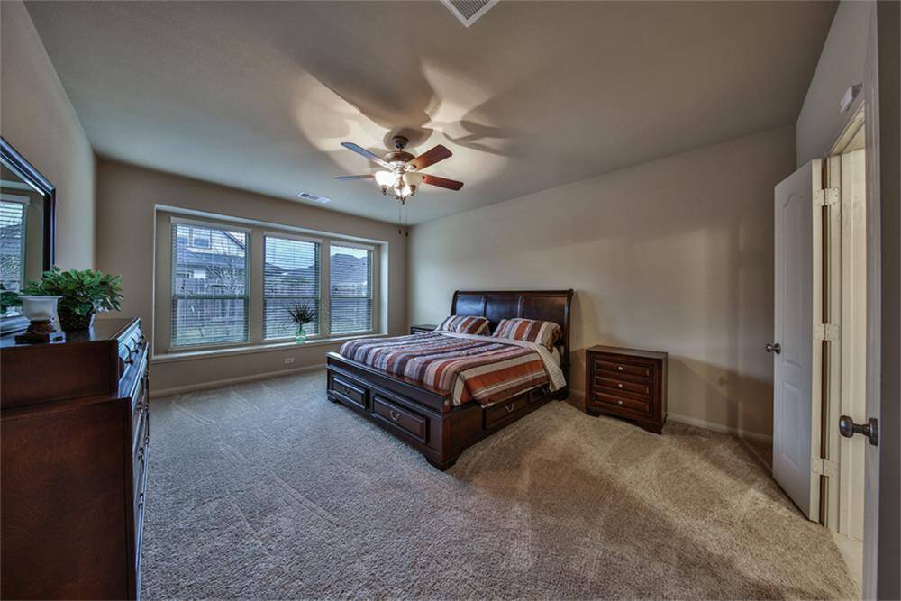 The primary suite is a true retreat, featuring high ceilings, charming box seat windows, a ceiling fan, and plush carpeting for cozy comfort—an ideal way to start and end your day!