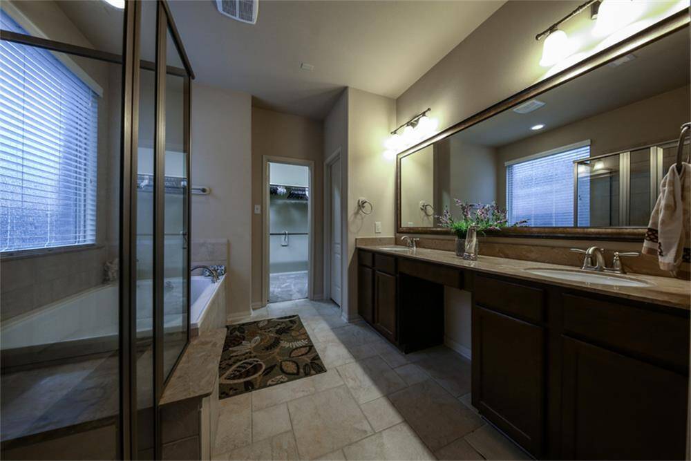 Luxurious en-suite bath features upgraded his-and-her vanities with under-mount sinks, elegant marble stone countertops and matching backsplash, framed mirrors, and a dedicated makeup sitting area. Plus, enjoy a spacious walk-in closet for all your wardrobe needs!