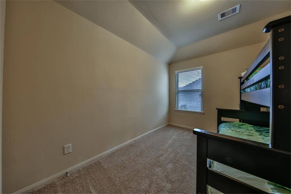 One of the secondary bedrooms features high ceilings, a spacious walk-in closet, and plenty of room to make it your own.