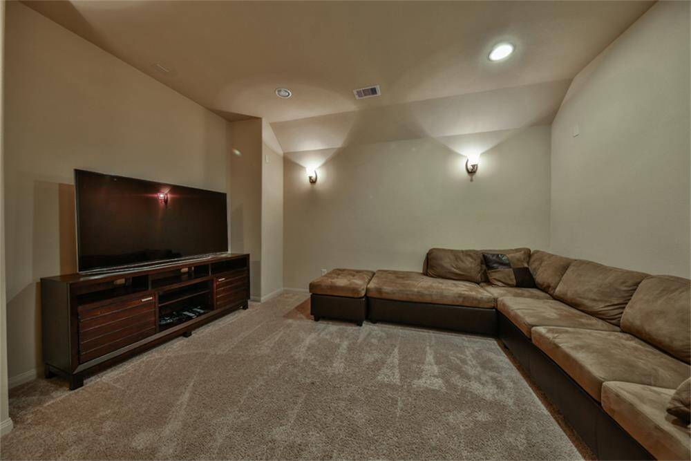 French doors open to a fantastic media room featuring high ceilings and pre-wiring for surround sound—perfect for movie nights and entertaining!