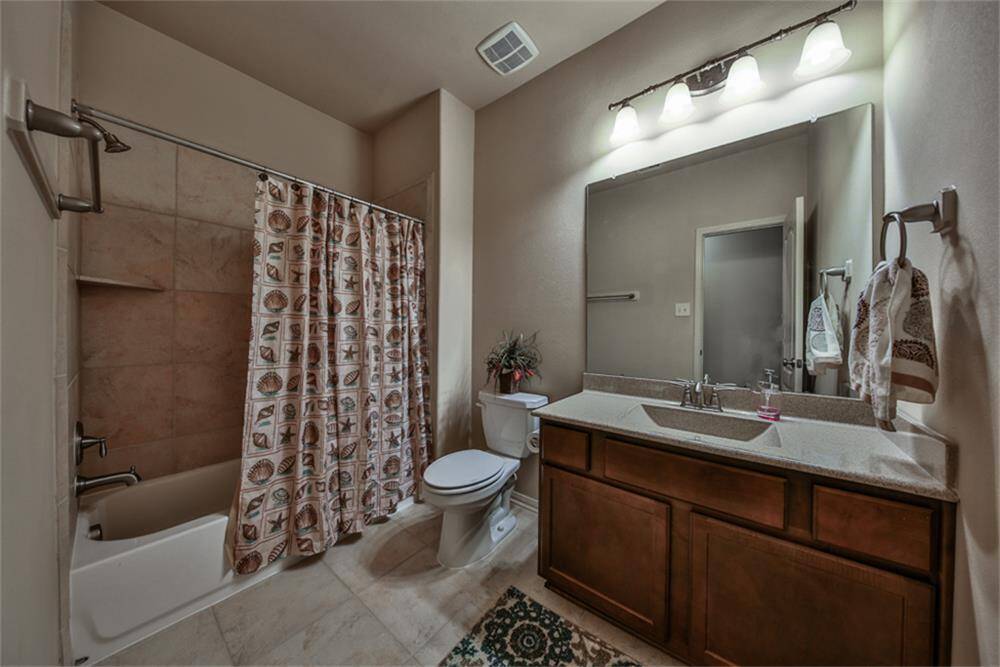 The right wing includes a full bathroom featuring upgraded hard surface countertops, stylish cabinetry, modern light fixtures, and an upgraded tile surround in the tub/shower area for a polished finish.