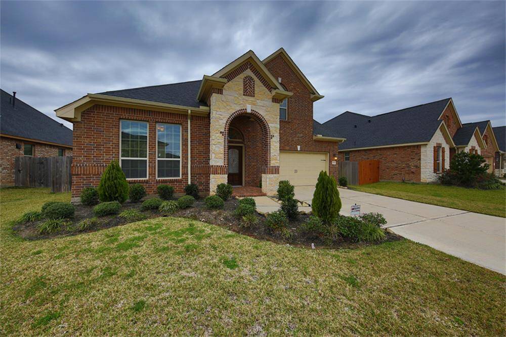 Beautiful two-story home showcasing an upgraded stone and brick elevation for stunning curb appeal.