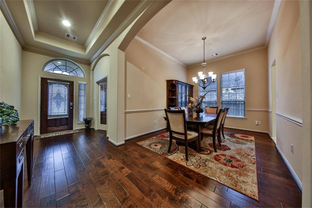 Dramatic entry features soaring coffered ceilings with crown molding, recessed lighting, elegant arched doorways, and upgraded hardwood floors throughout. Step through the upgraded French panel glass doors into your private study—perfect for work or relaxation!