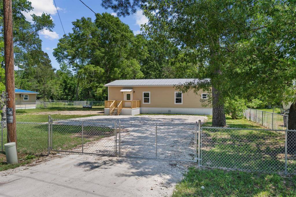Cozy one-story home with a welcoming front porch, nestled on a spacious, fenced lot surrounded by mature trees. Ideal for privacy and outdoor enjoyment.