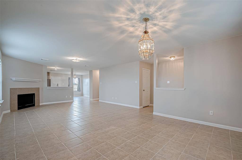 The spacious living room is centered around a wood-burning fireplace, a striking focal point that adds warmth and character to the room.