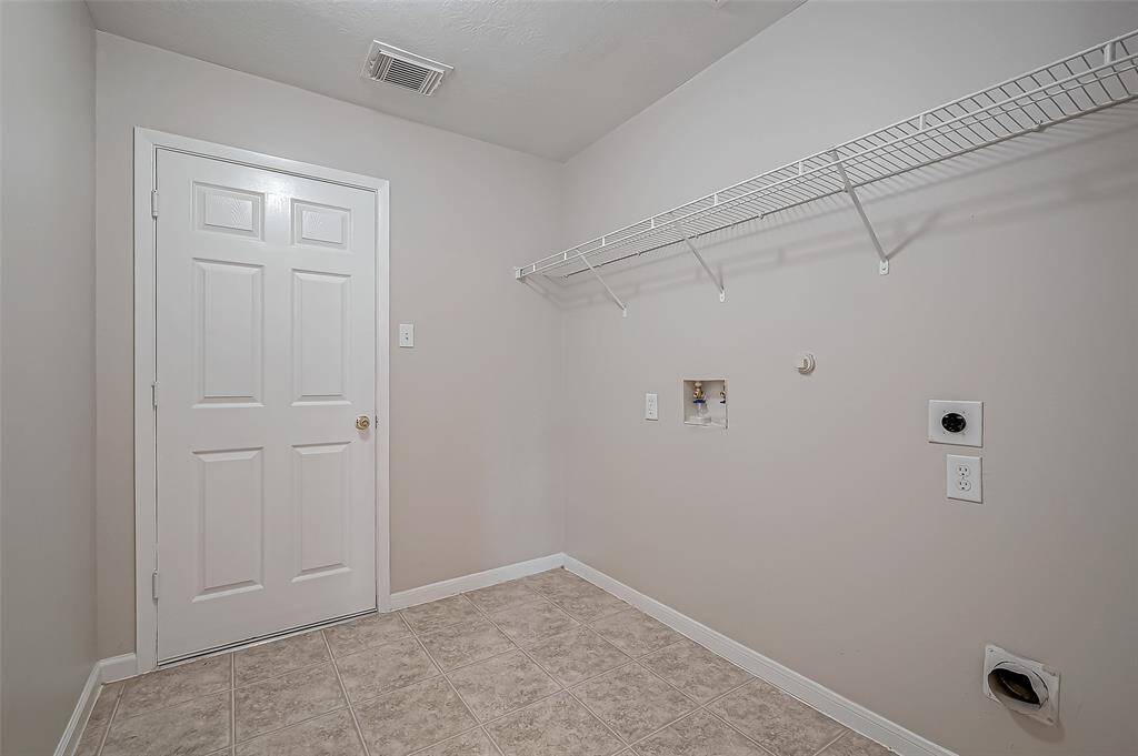 The laundry room offers ample space for both a washer and dryer, with an overhead rack for additional storage.