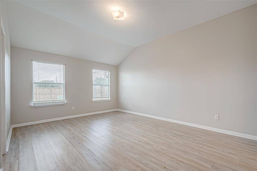 Large windows fill the primary bedroom with natural light, enhancing its open and airy feel.