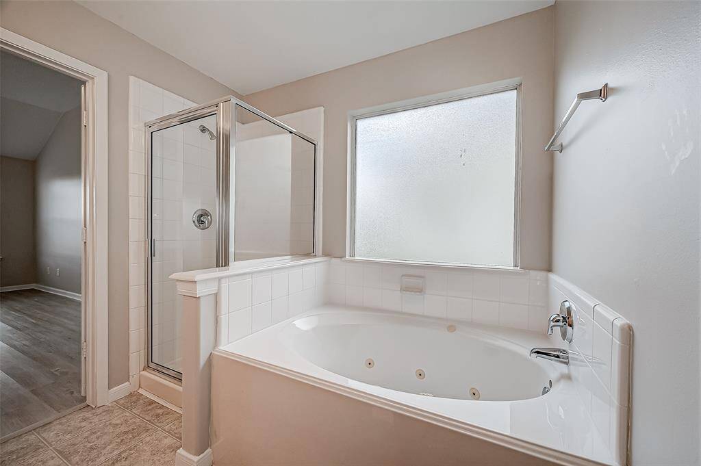 The enclosed shower sits beside a soaking tub, providing both convenience and relaxation options.