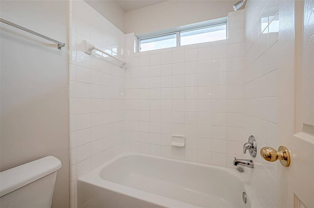 A shower/tub combination completes the bathroom, with a clean and modern design.