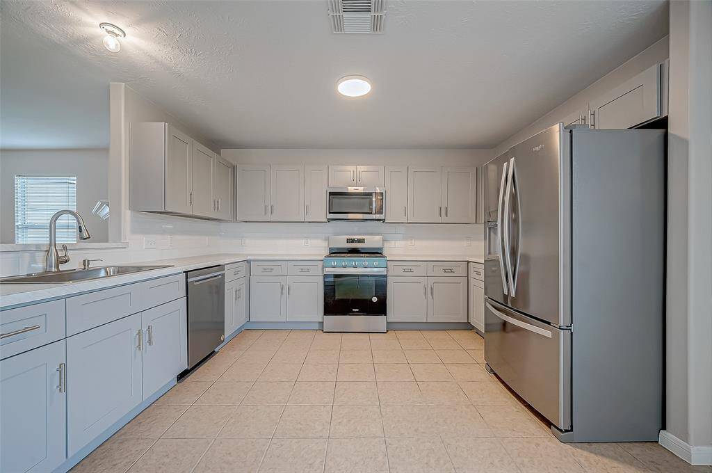 The kitchen features an abundance of cabinetry and expansive countertops, providing ample storage and workspace for cooking and meal prep.