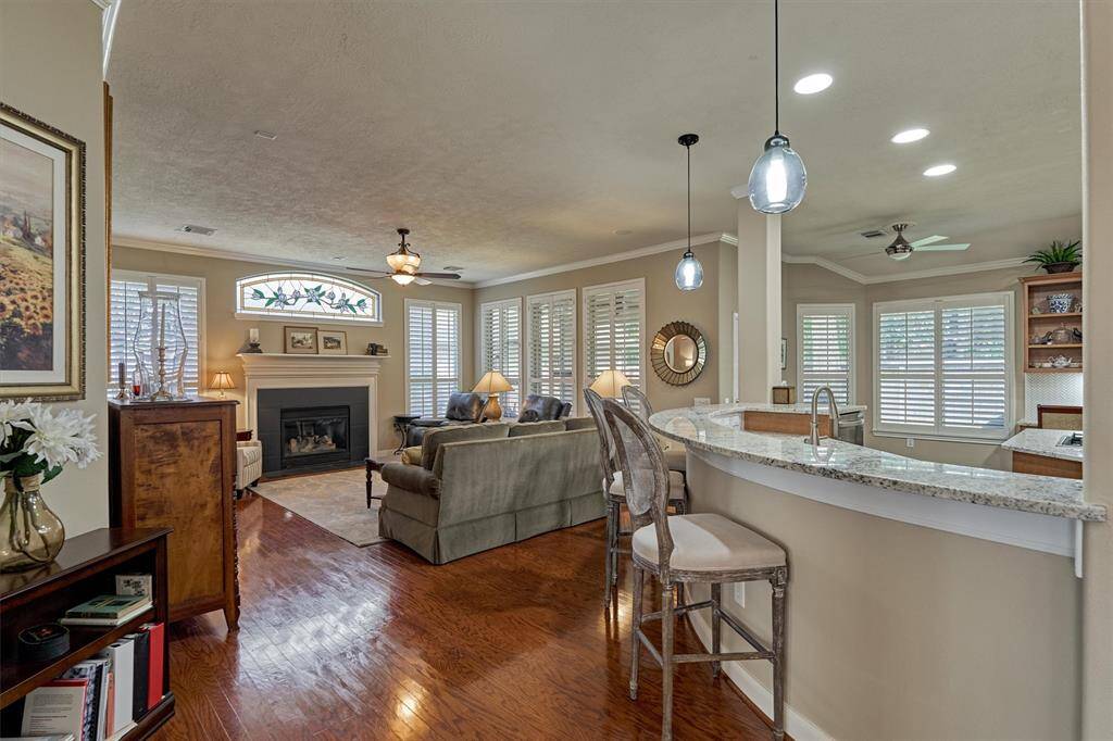 The kitchen seamlessly connects to the living area, featuring neutral paint and crown molding.