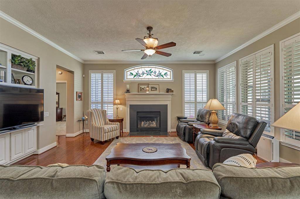 The elegance of this home is enhanced by crown molding, plantation shutters throughout, and immaculate engineered hardwood floors.