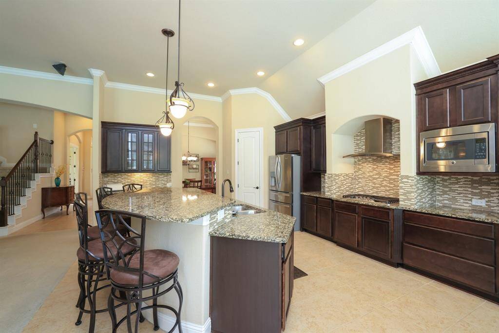 Ample space between cooktop and island. 5 burner gas cooktop.
