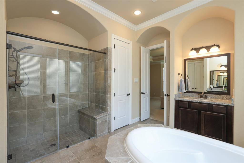 Very large shower area with sprayer and seat. Another bath closet.