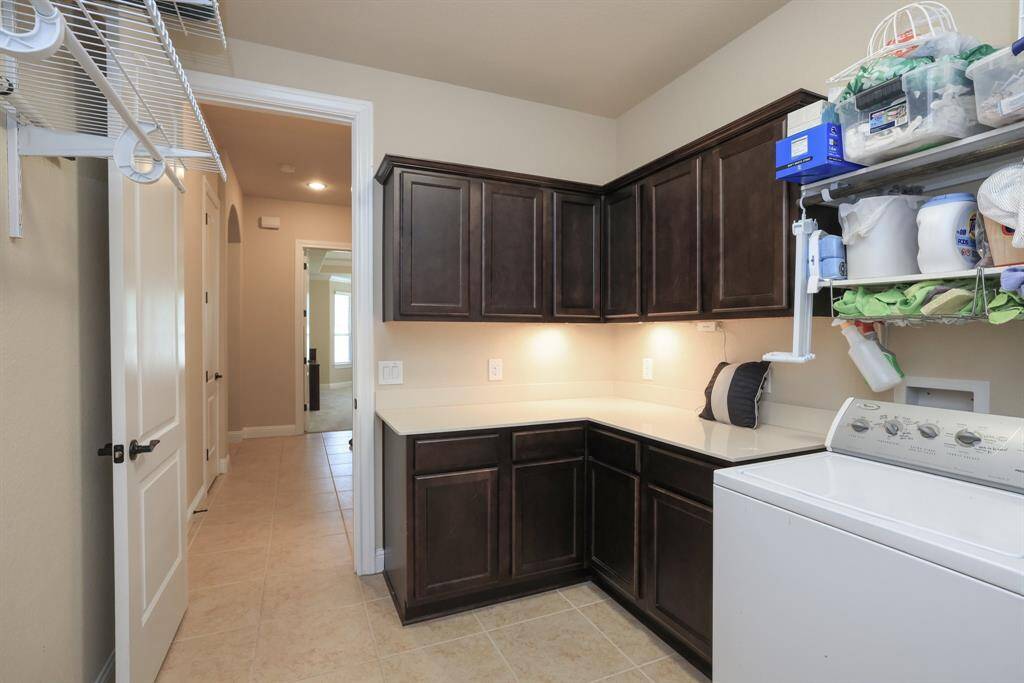 So nice to have a laundry room with upper and lower cabinets for storage. And plentry of hanging space. Door to garage.