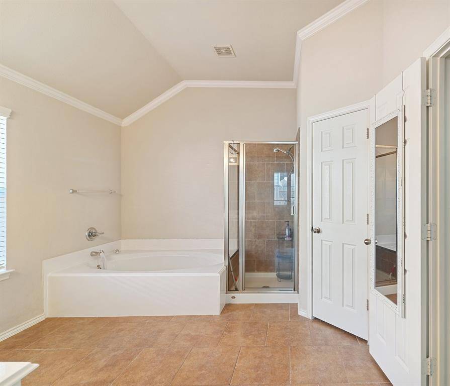 The primary bathroom also offers a relaxing over-sized bathtub and a spacious walk-in shower, creating a perfect retreat for unwinding and rejuvenating.