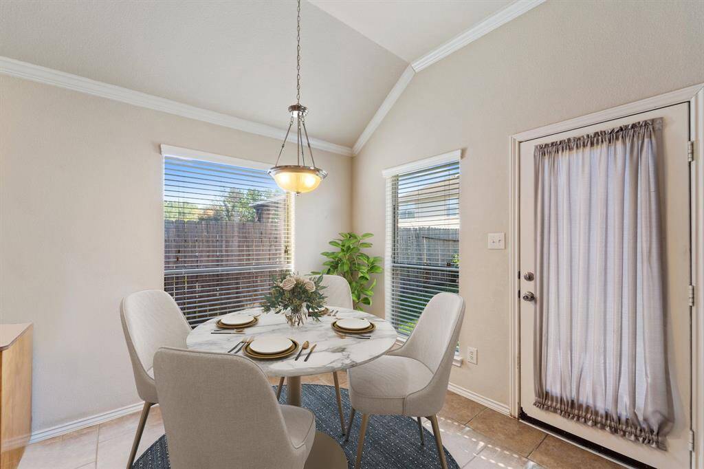 The breakfast area, located next to the kitchen, features windows with privacy blinds, crown molding, and a charming chandelier. *Virtually Staged*