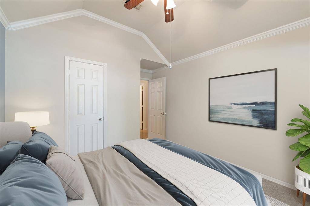 This cozy bedroom features soft carpet flooring, elegant crown molding, and a ceiling fan for year-round comfort and charm. *Virtually Staged*