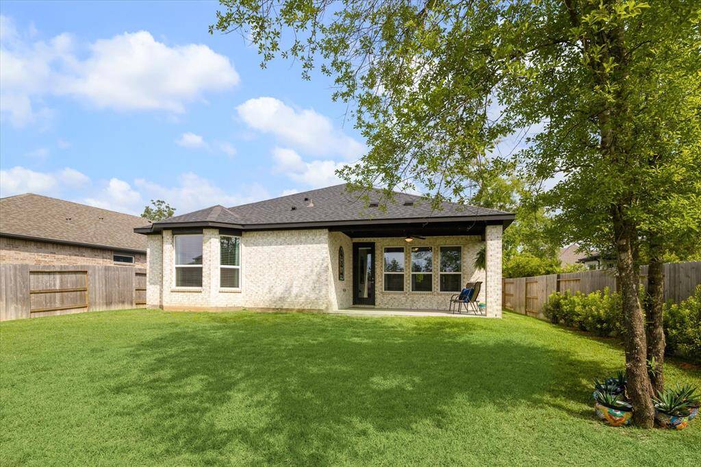 Spacious backyard with shade tree.