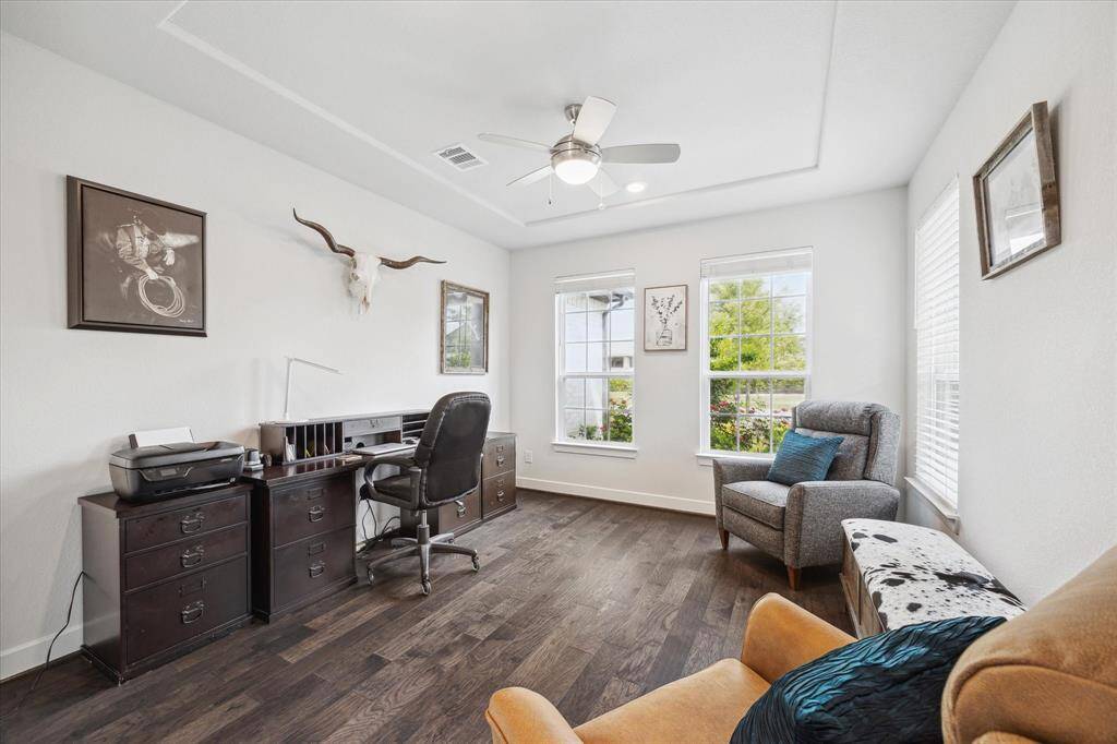 Flex room with large windows allowing natural light. Looking out at the roses and landscaped front yard.