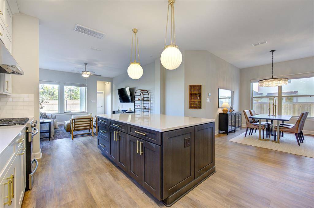 The kitchen opens to the living and dining areas, creating a perfect space for entertaining while maintaining a bright, open feel.
