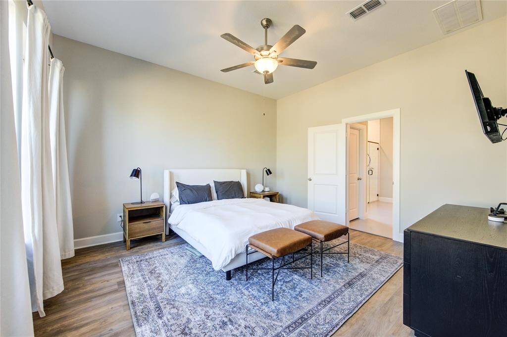 A gorgeous  first floor primary suite with spacious proportions, large windows, and a serene color palette.