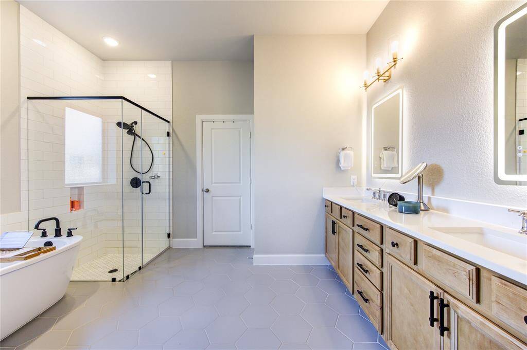 The spa-like ensuite features dual vanities, a soaking tub, a separate walk-in shower, and quartz countertops—perfect for relaxation.
