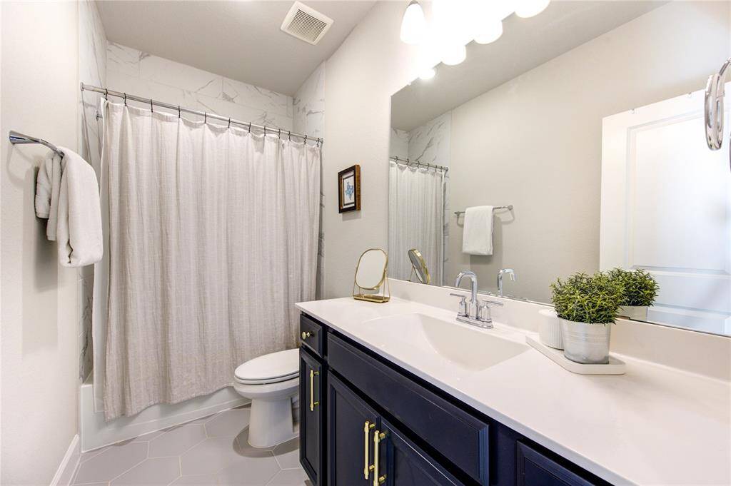 A stylish full bath upstairs with modern fixtures, a tub/shower combination, and quartz countertops.