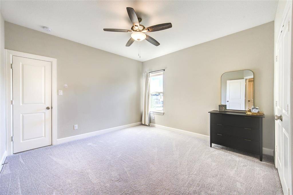 Three generously sized bedrooms with plush carpeting, ceiling fans, and ample closet space.