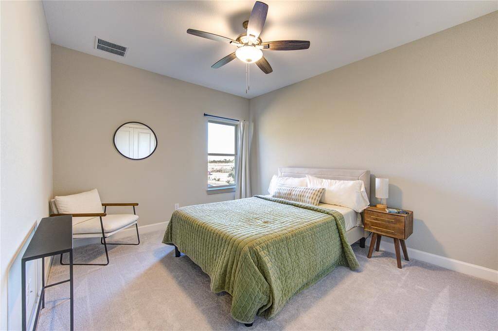 The spacious second and third bedrooms upstairs offer a cozy retreat with plush carpeting, creating a soft and comfortable feel underfoot. Large windows allow for ample natural light, enhancing the bright and airy ambiance of each room.