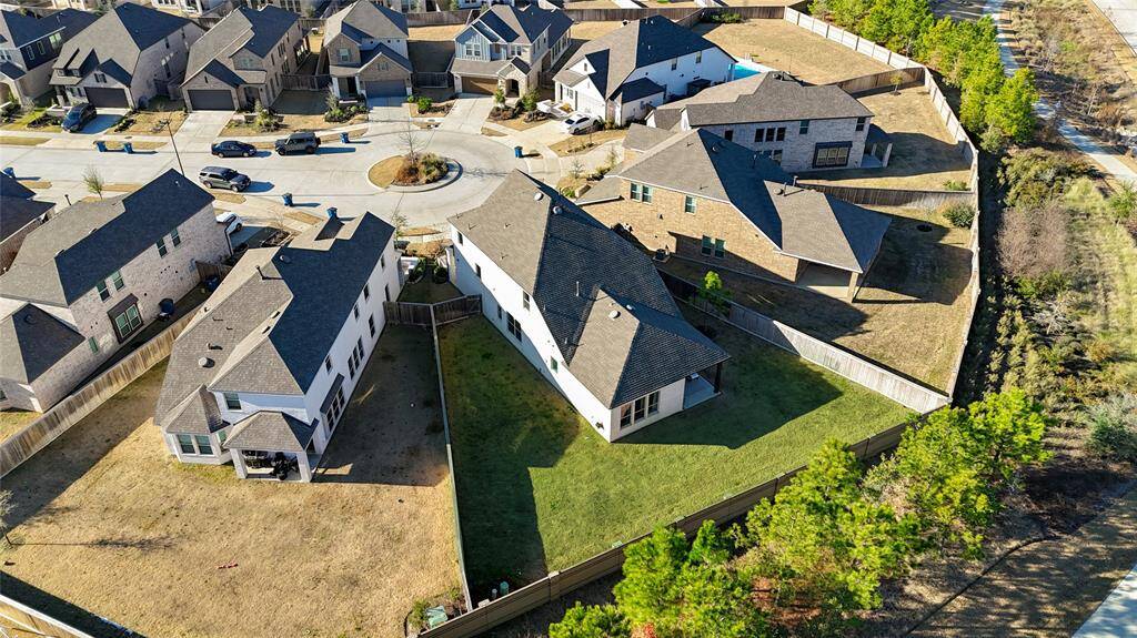 The expansive backyard is beautifully showcased from above, highlighting its lush green space and open layout. With no direct back neighbors (if applicable), this private outdoor retreat offers a peaceful setting with ample room for entertaining, play, or future enhancements.