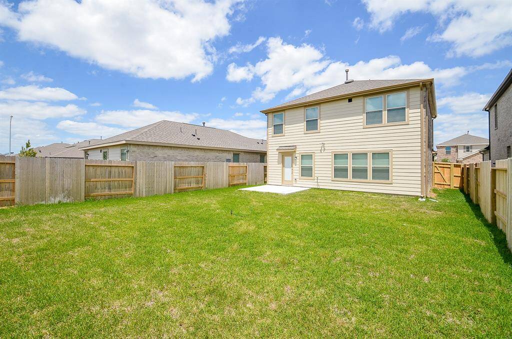 Rear view of the home featuring the expansive Backyard for out door living and entertainment.
