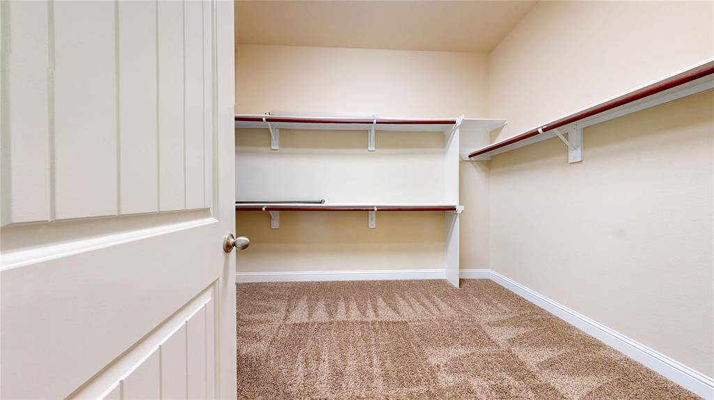 Large Primary Bedroom walk-in closet with ample shelving and hanging space, offering great storage and organization potential.