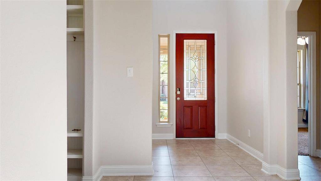 Bright entryway with neutral tile flooring create an inviting atmosphere.