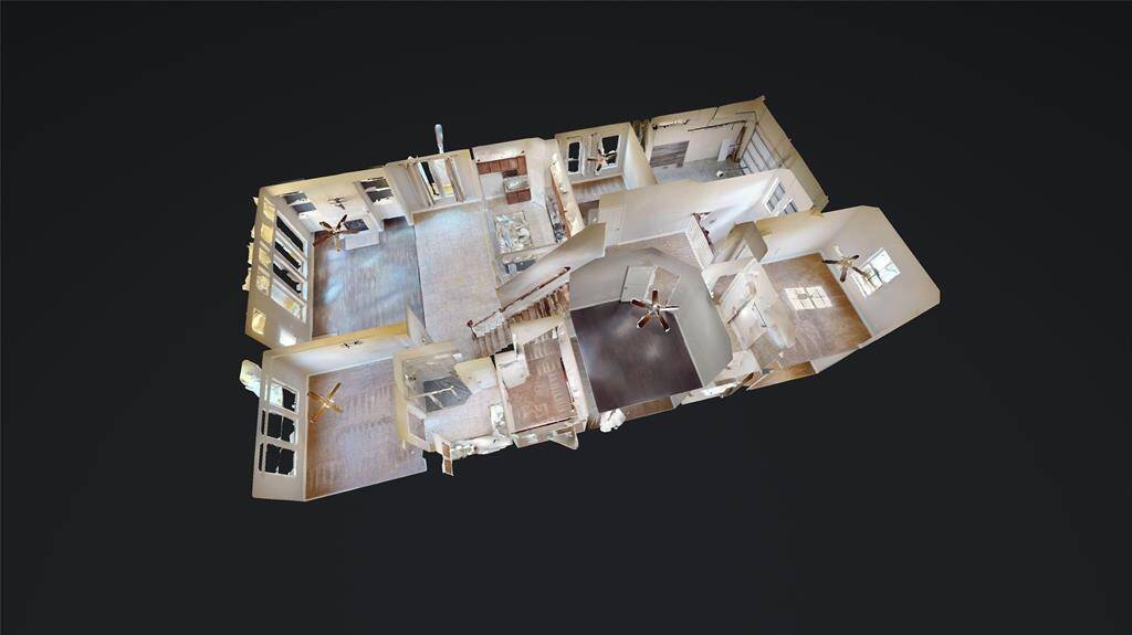 This image shows a 3D floor plan of a spacious home, featuring multiple rooms with large windows and ceiling fans. The layout includes distinct living areas, a central staircase.