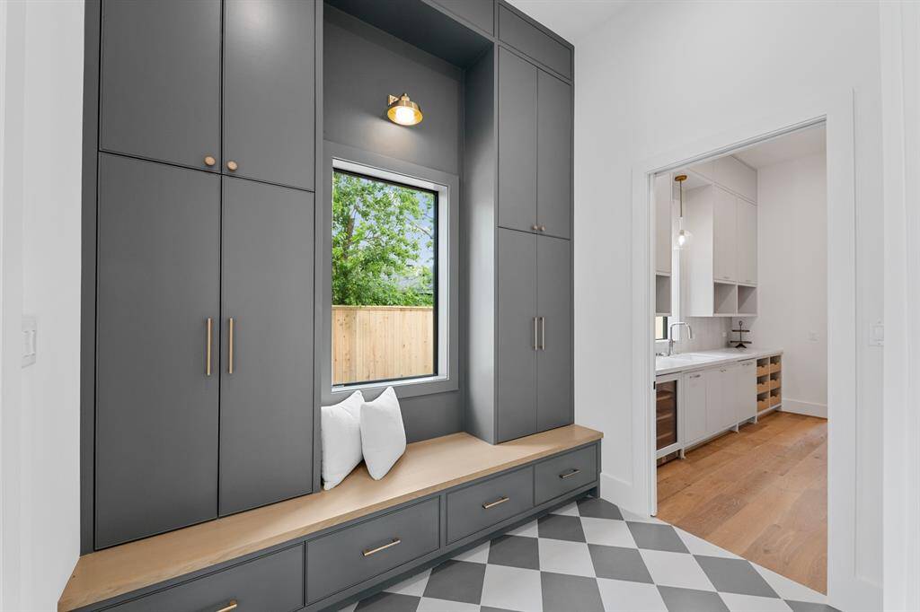 The mudroom blends function with elevated design, featuring custom cabinetry, designer tile flooring, and a built-in white oak bench for seamless storage and style. Thoughtfully placed just off the entry, it’s a beautifully practical landing space for daily life.