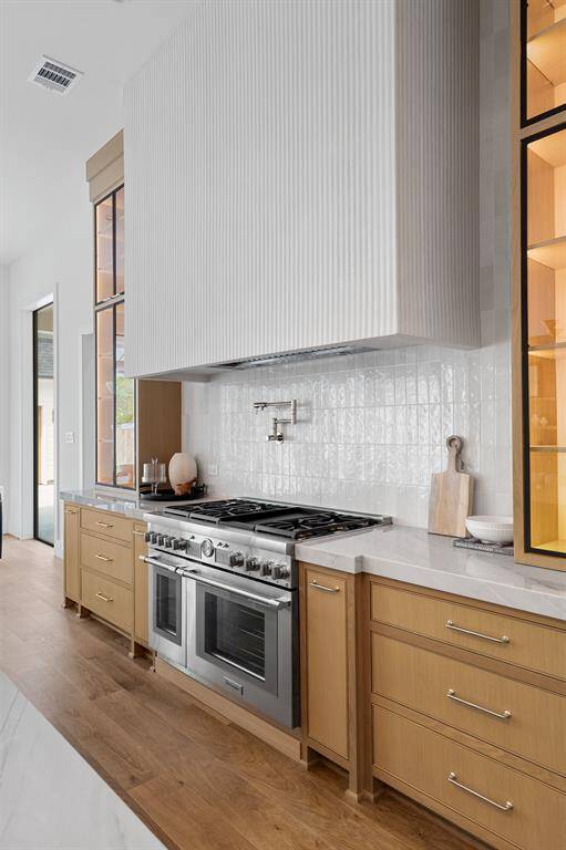 Your kitchen is adorned with a custom fluted, plaster hood range over a brand new Thermador gas range and pot filler.