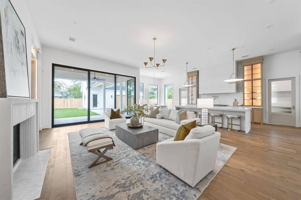 Designed for both gathering and retreat, the living area features custom white oak built-ins with integrated lighting, adding warmth and dimension to the modern layout. Wide-plank flooring and thoughtfully placed windows enhance the open, airy ambiance.