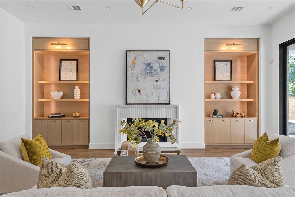 A seamless extension of the home’s open-concept design, the living room is anchored by artisan craftsmanship—from the hand-applied plaster fireplace to the custom millwork and ambient lighting. Every detail is considered, every line intentional.
