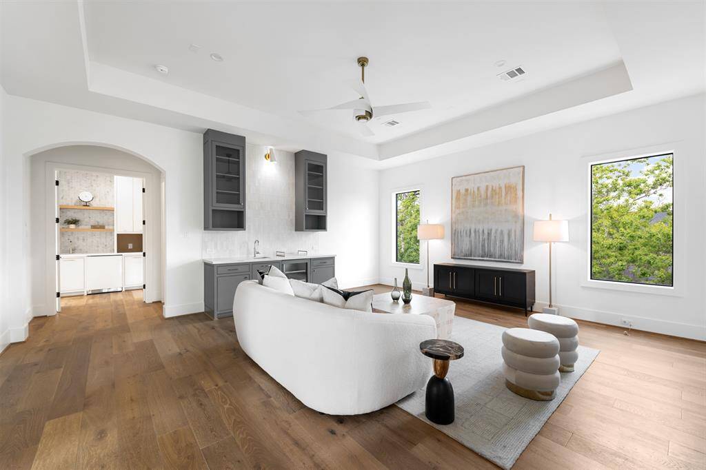 ace upstairs is designed for both comfort and style, featuring a sleek wet bar with custom cabinetry for easy entertaining. Large windows flood the room with natural light, while hand-selected fan white oak flooring adds a warm, timeless touch to the space.